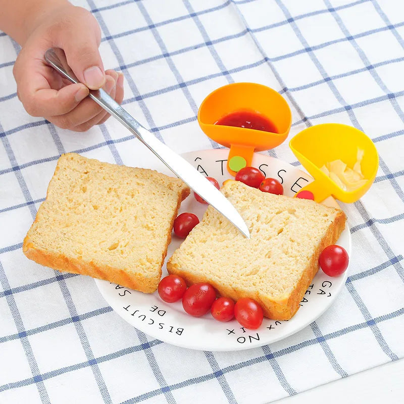 Four colourful sauce holder bowls clipped to plates