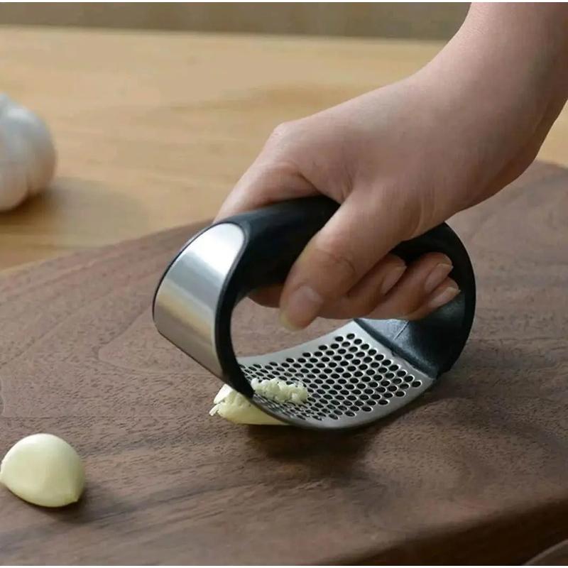 Stainless steel garlic mincer tool in use