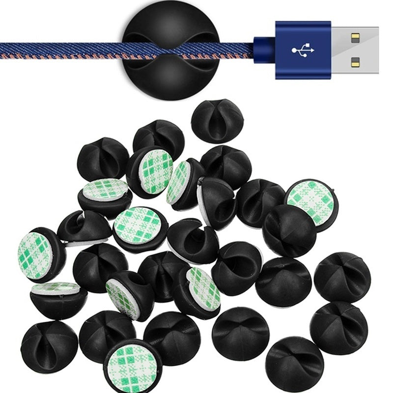 Black cable clip organisers holding USB cords on desk